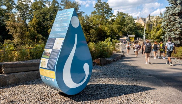 Photograph of a water droplet sculpture with an upside down question mark on it.