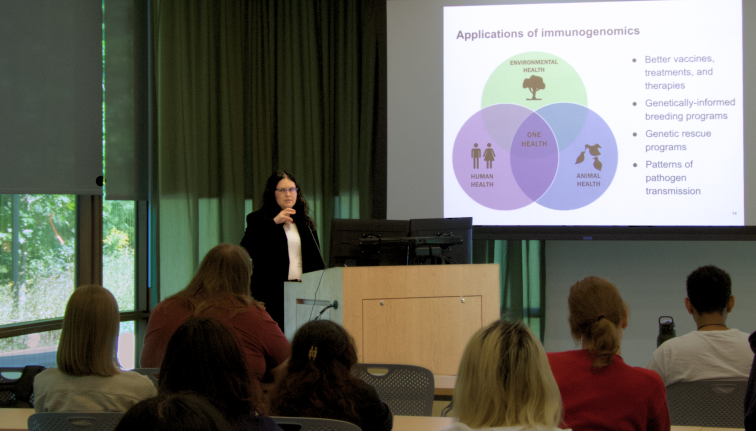 Woman presents research with projector to audience