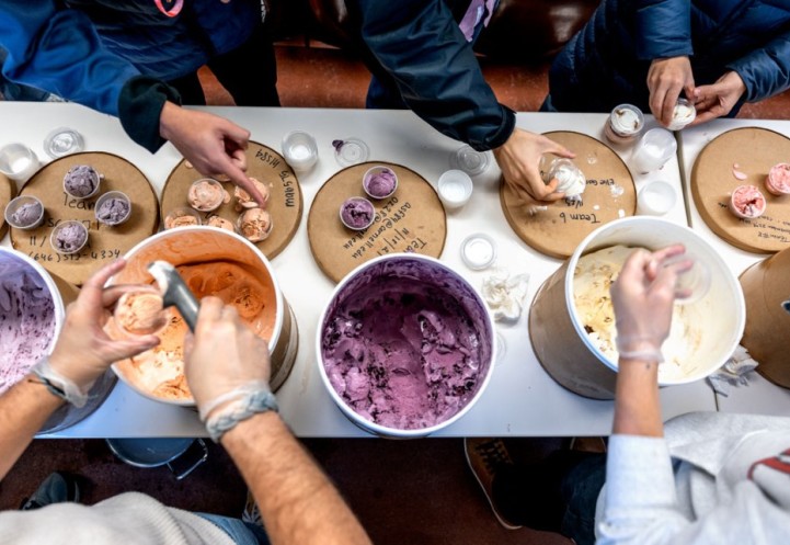 Teaching assistants scoop out the ice cream flavors and hand them to students 
