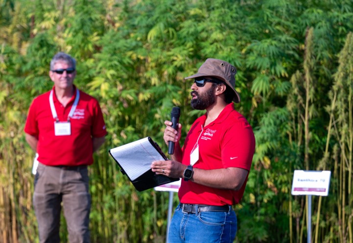 agritech scientists speak in front of hemp research plot