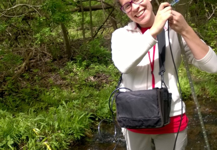 Person standing in ankle-high water taking measurements