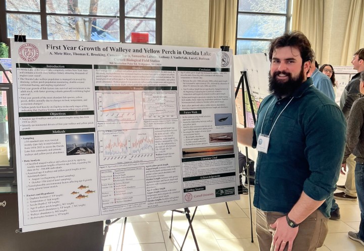 person standing next to poster at conference