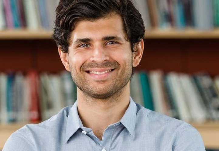 Professor Usmani standing in a library