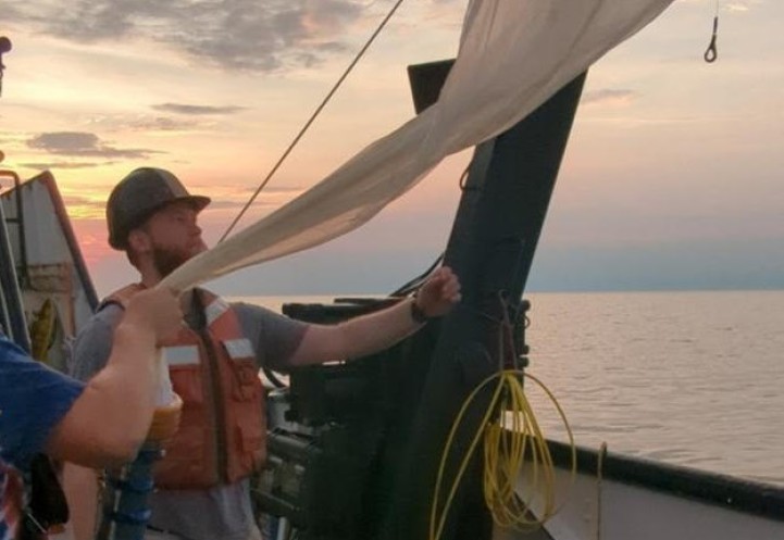 person hauling in a tow net