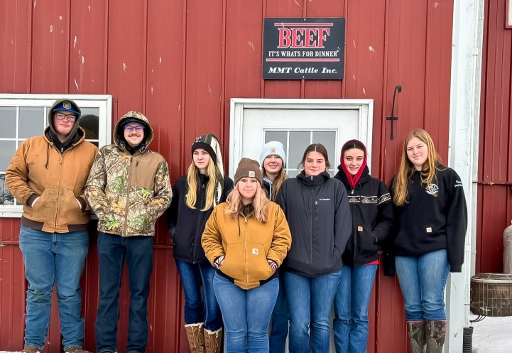 a group of young people stand together in front of a building
