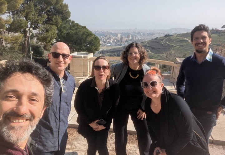 5 individuals stand and smile for a selfie
