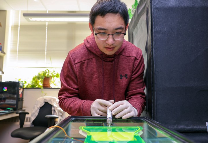 Yicong Fu, mechanical engineering doctoral student, injects dye into his custom-built, bio-inspired thermal dispenser to observe how particles disperse.