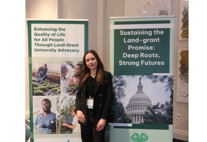 Kate Stephens ’26 posing next to banners at the CARET conference