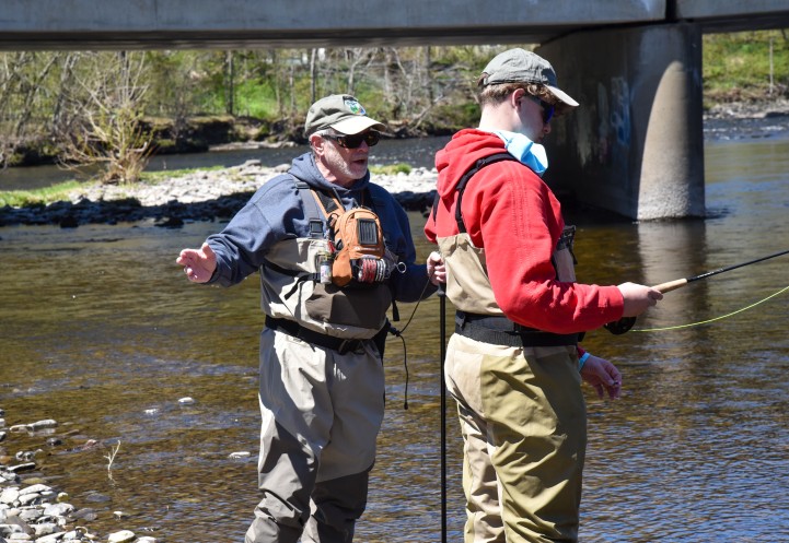 A Trout Unlimited volunteer on stream with a 4-H youth participant