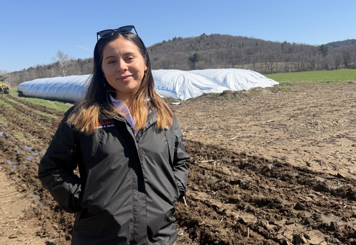 A woman stands in a field.