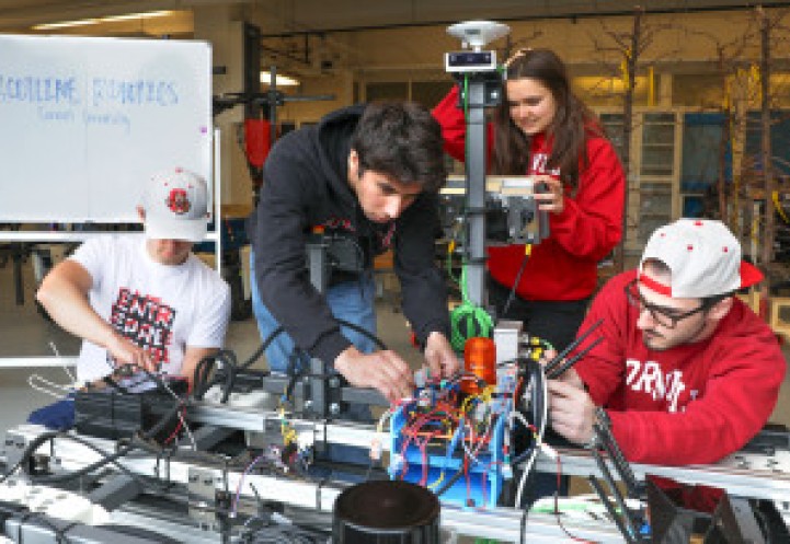 A team of Cornell students work on a prototype of their weed-killing robot