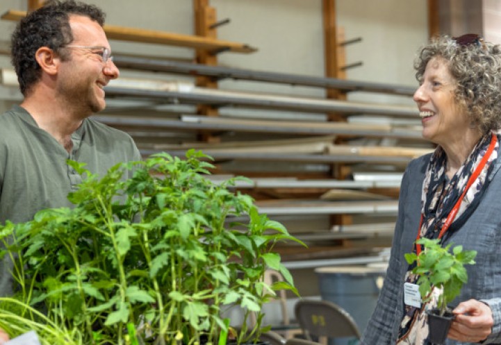 Laurie VanNostrand (right), Cornell Cooperative Extension master gardener coordinator in Wayne County and statewide coordinator for the Vegetable Variety Trial Garden project, chats with a master gardener volunteer at a plant pick-up day on campus on May 12. 