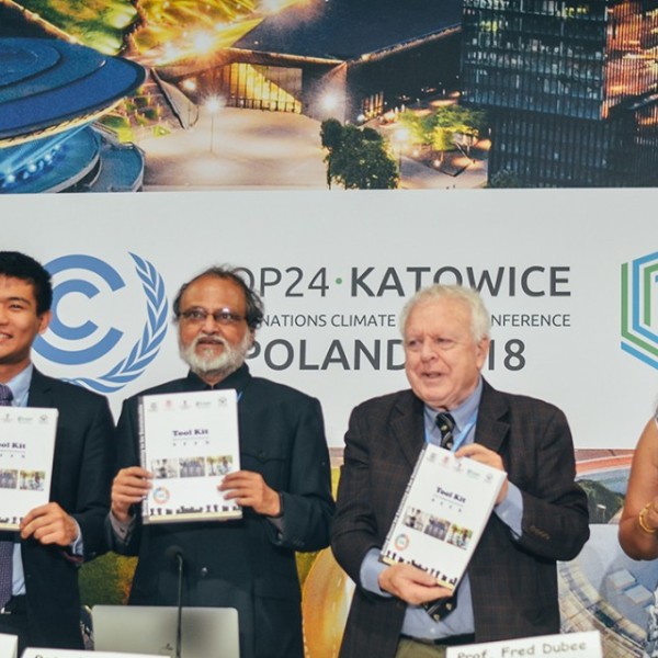 Zeyu Hu, Rajendra Shende, Frederick Dubee, and Vinita Apte holding toolkits at COP24