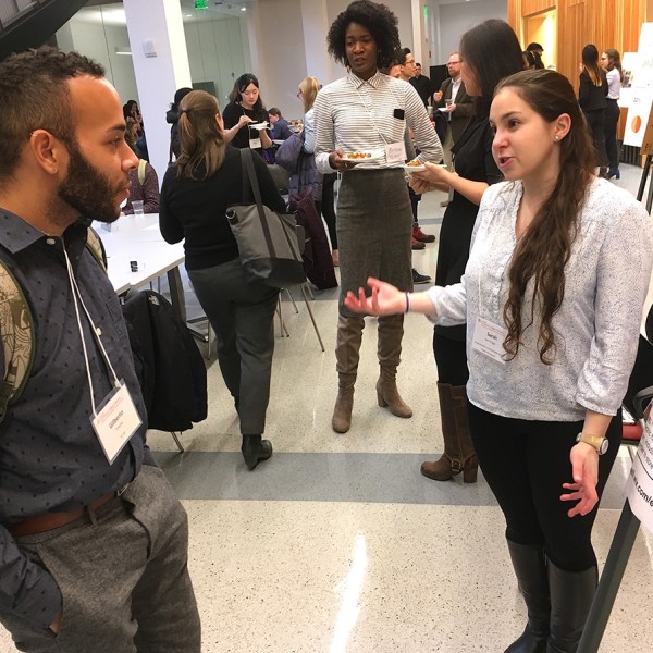 Gilberto Trevino listens to Sarah Barr Engel discuss wind energy at the poster session at the Cornell Business Impact Symposium
