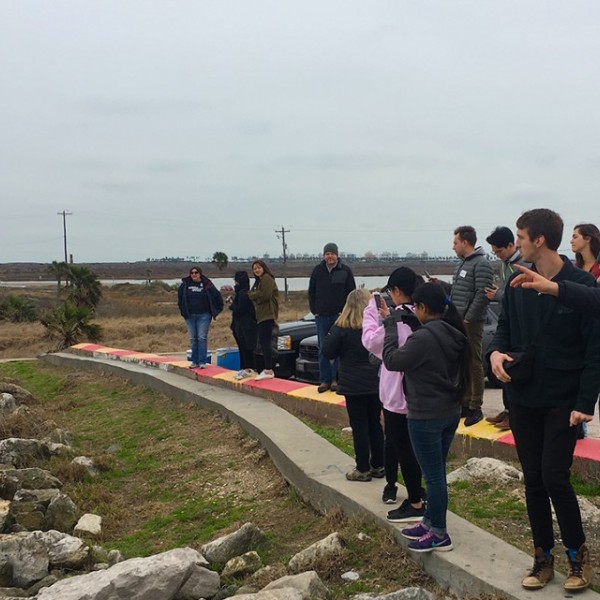 Students stand along a levee