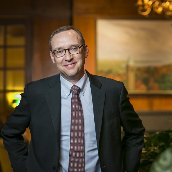 Kevin Hallock stands in front of a painting