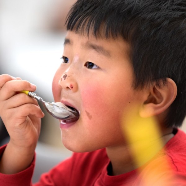 Child eats ice cream with a spoon