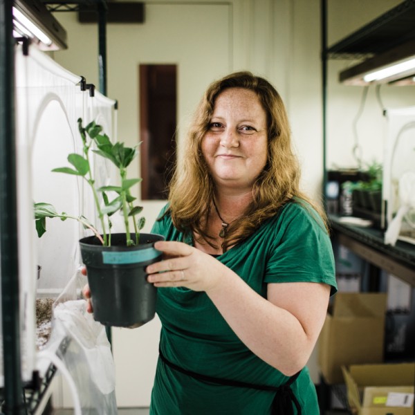 Tory Hendry holding a plant in her lab