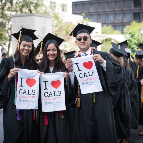 graduating students hold up shirts that say "i heart CALS"