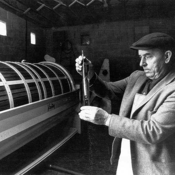 researcher uses a hydrometer in front of a cask