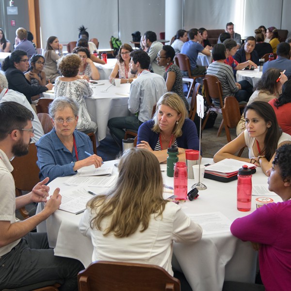 Conference goers discuss around table