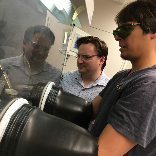 chemist has arms in safety system while other researcher looks on
