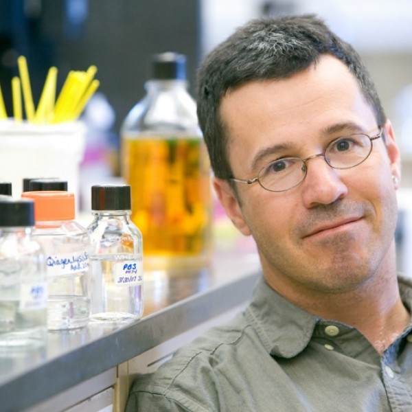A man sits next to a counter with glass jars on it