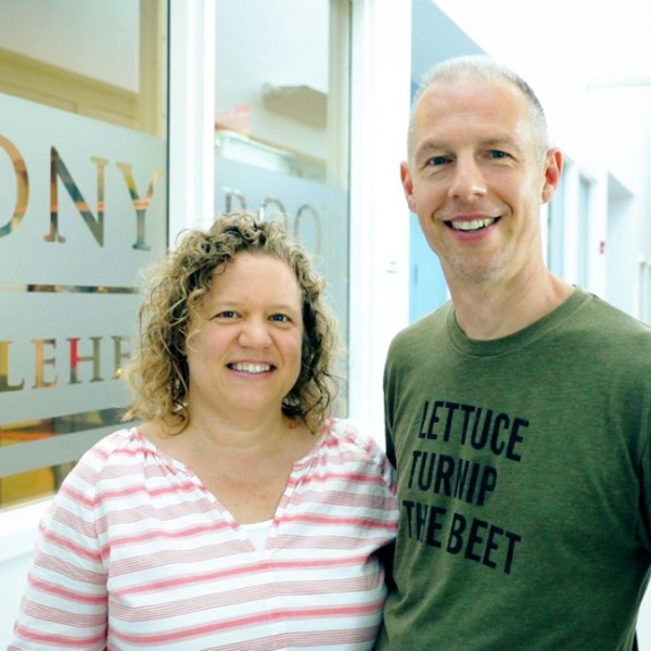 A man and woman standing side by side in a building
