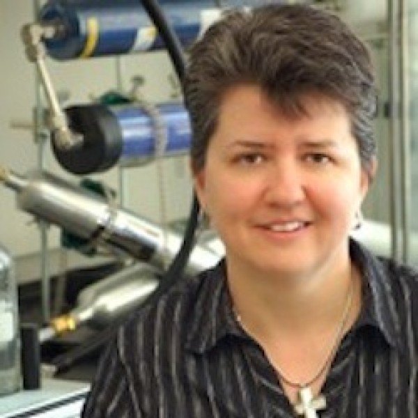 A woman stands in front of laboratory equipment in a laboratory