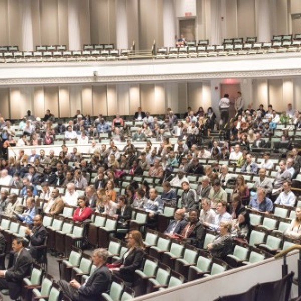 A group of people sitting in a lecture hall at a conference