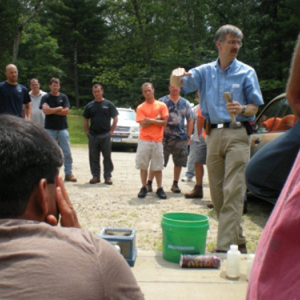 A group listens to a man from the Cornell Local Roads Program speak