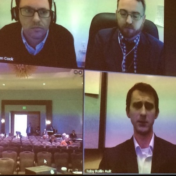 A screenshot of three men calling into a live media conference