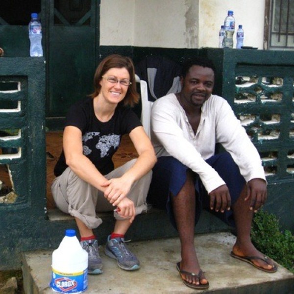 A man and a woman sit on steps of a house in Liberia