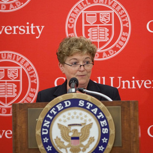 A woman stands at a podium and speaks