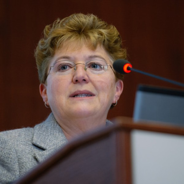 A woman stands at a podium and speaks