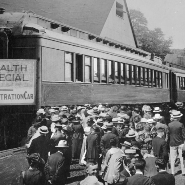 A group of people wait for a train with a special label in the 20th century