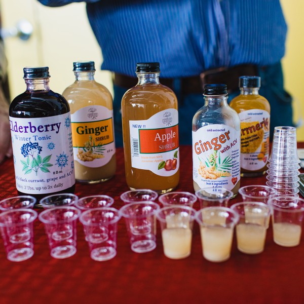 Samples of tonics in small cups with bottles behind
