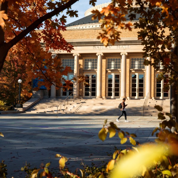 A student walking outside in the fall