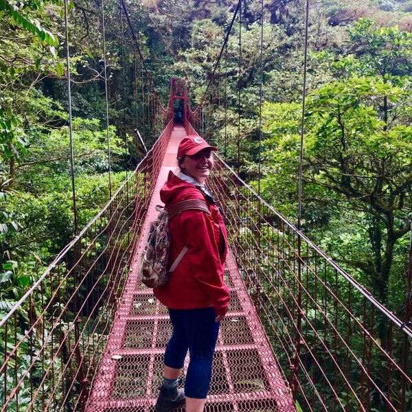 A student on a bridge in a forest