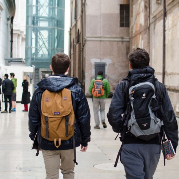 Two male students walking by a monument 
