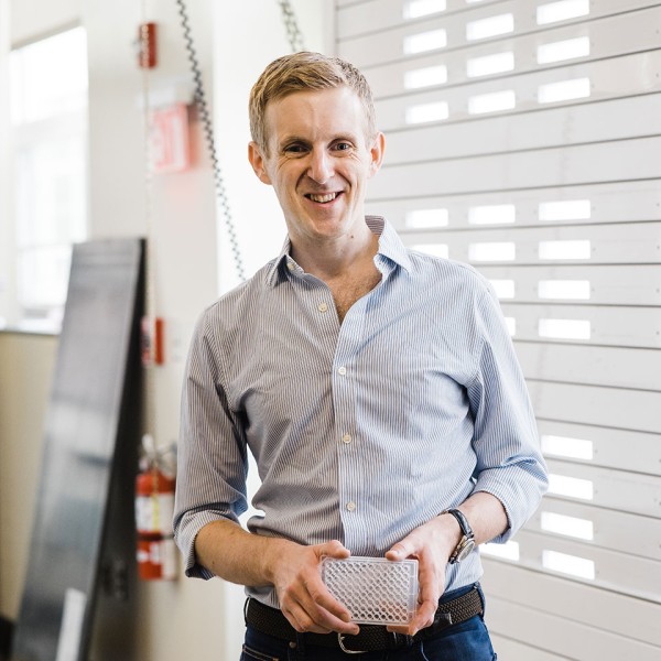 Buz Bastos stands by a window in his lab.