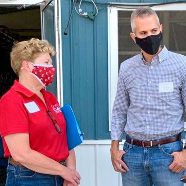 a women and two men standing outside talking 