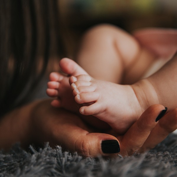 a mother holding her baby's feet 