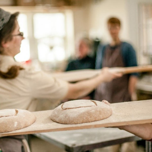 Women working in a bakery kitchen with bread dough