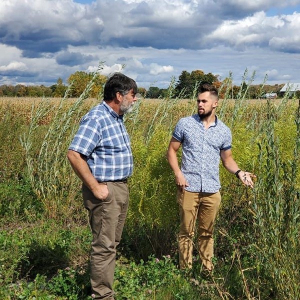 Two men standing in a field and talking