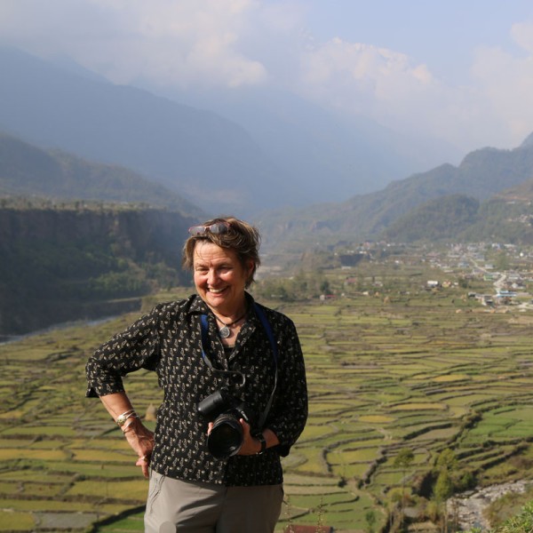 Linda McCandless holds a camera in the mountains of Nepal