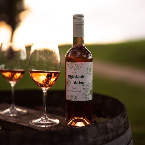 Wine bottle and two wine glasses at sunset.