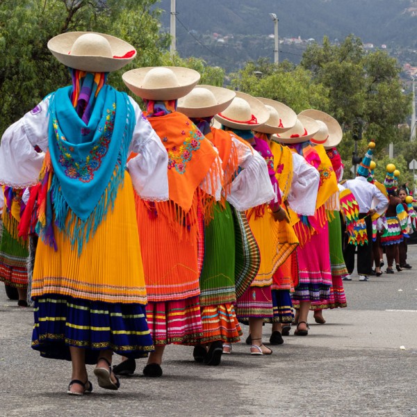 Women dance in the street wearing colorful skirts