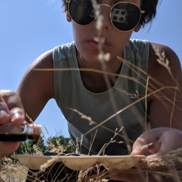 a woman lays in the grass conducting a soil acidity test