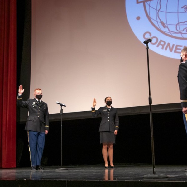 ROTC graduates standing on a stage being sworn in